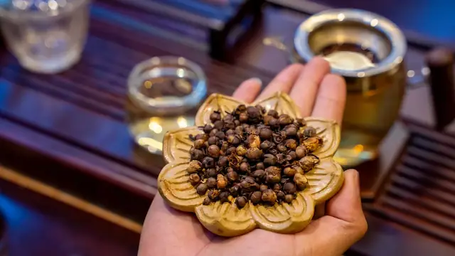 Hoa chè khô được nâng trên tay trong buổi thưởng trà